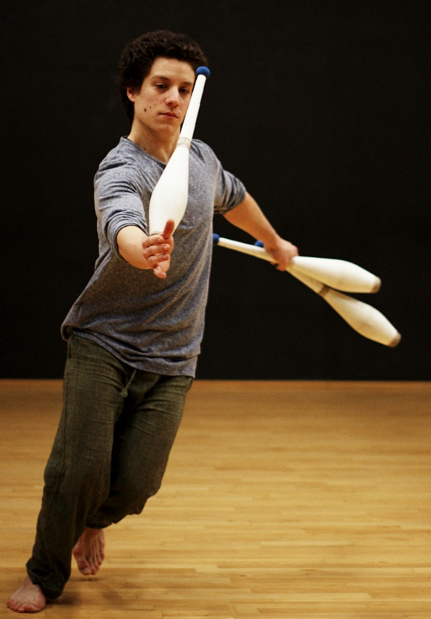 Pendant une session de jonglerie au Subsistances, Martin court sur le parquet avec une massue en équilibre sur le poignet.