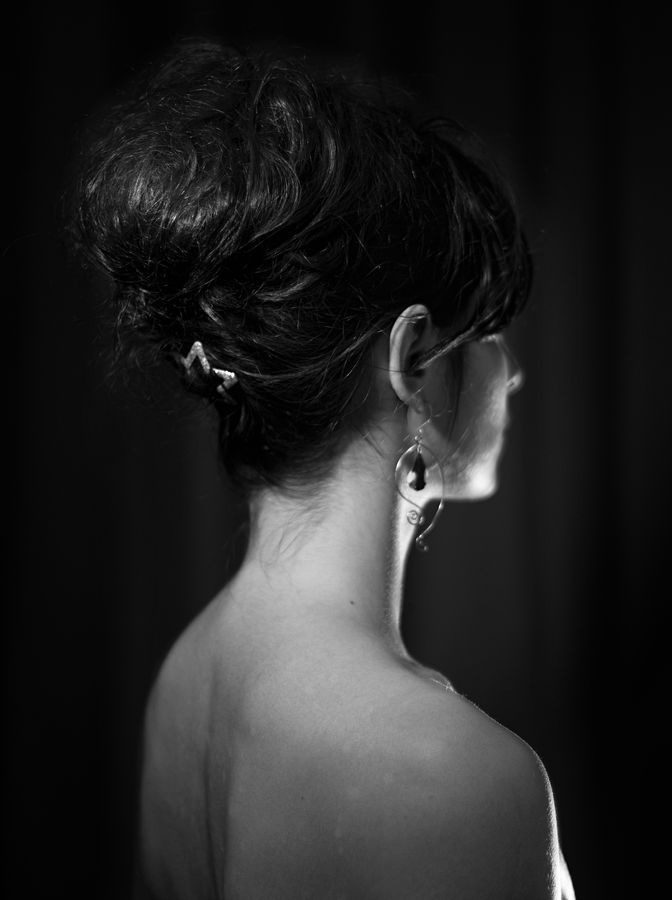 Portrait trois-quarts dos, noir et blanc, de Mathilde. Ces cheveux sont remontés sur sa nuque et maintenus par une barrette pailletée en forme d'étoile.