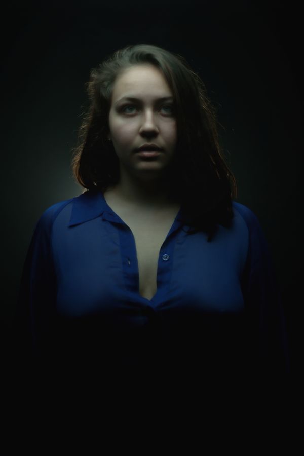 Pour ce portrait, Alice porte une chemise bleu en organza transparente. Elle a le regard perdu dans le vide et fait penser à une héroïne de série télévisée.