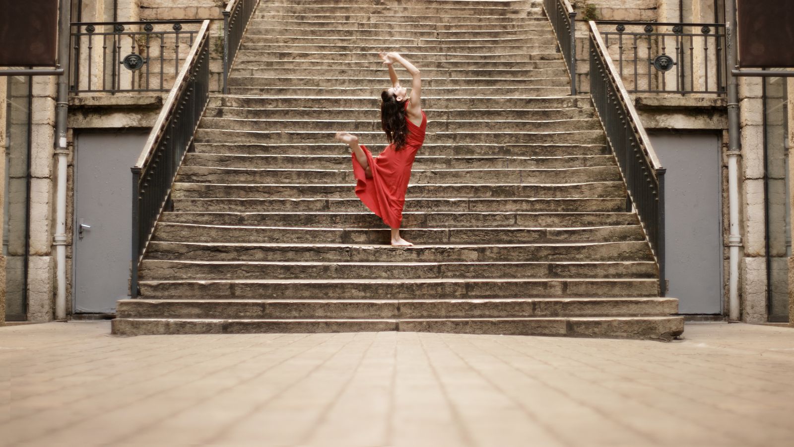 Mathilde, en robe rouge, fait de la danse contemporaine Passage Thiaffait. Elle a, alors une position très dynamique, comme un élan vers le ciel.