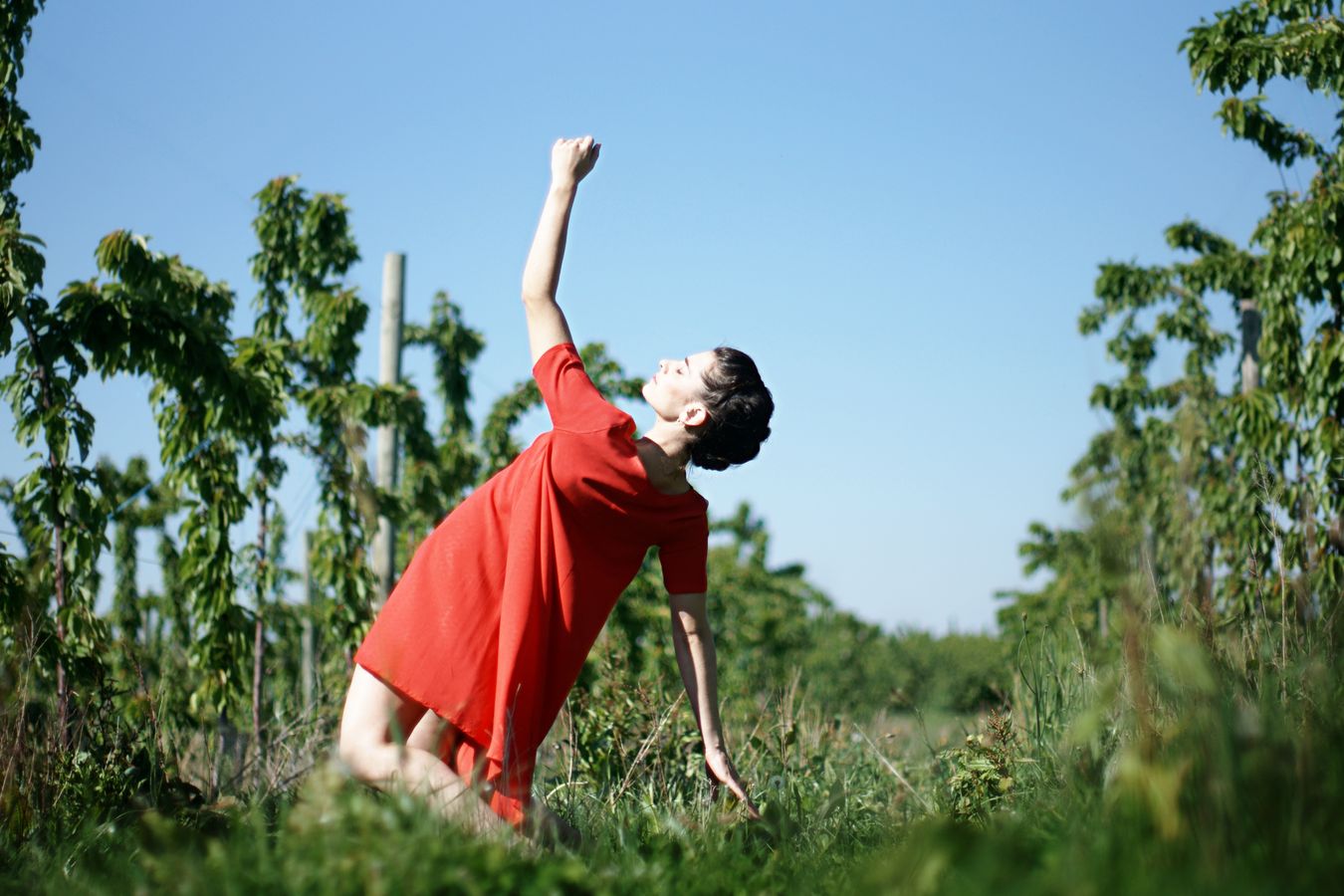 Au milieu des cerisiers de Saint-Laurent-d'Agny, Mathilde fait de la danse contemporaine en robe rouge. Son corps chute, alors en arrière comme si elle avait été renversée par le soleil.