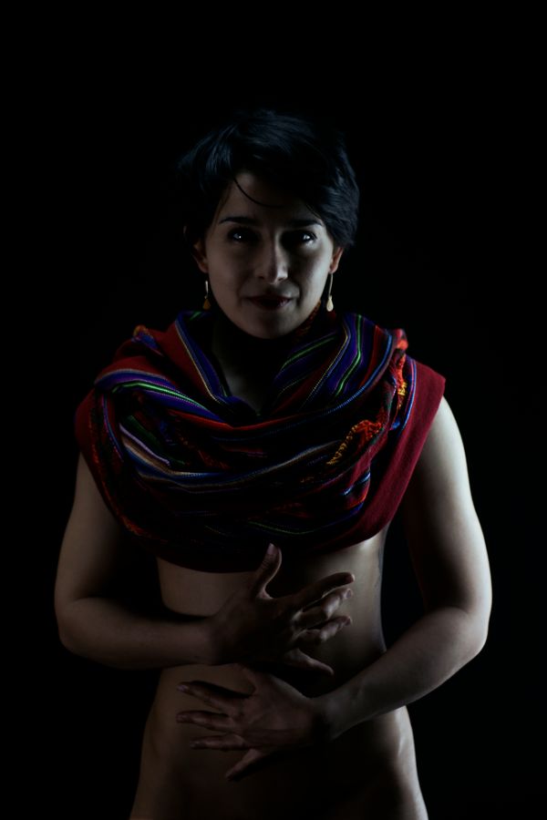 Portrait en clair-obscure de Iona, en studio, chez moi à Caluire-et-Cuire. Elle porte un plaid péruvien sur la poitrine et pose ses mains sur son ventre.