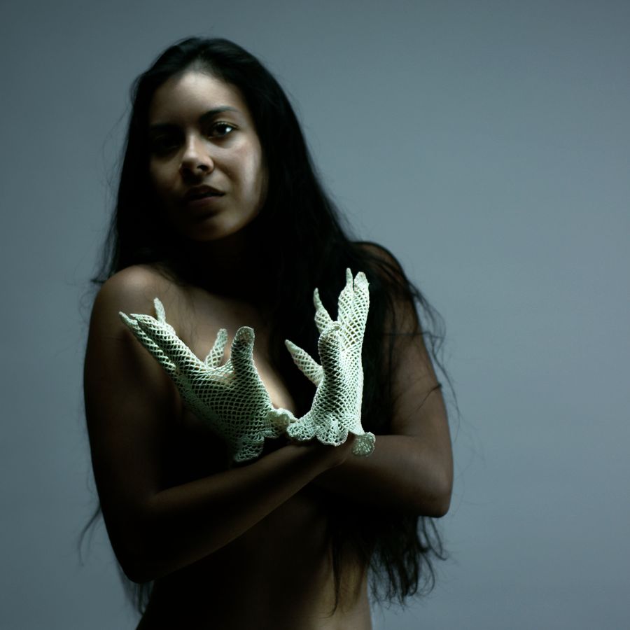 Ana porte des gants anciens en résille blanche, trop petits pour elle. Elle pose, alors devant le fond blanc de mon studio à Caluire-et-Cuire.