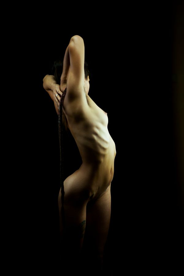 Annaïg fait un étirement en torsion, en studio, chez moi, à Caluire-et-Cuire. Son corps et à la fois extrêmement musclé et féminin.